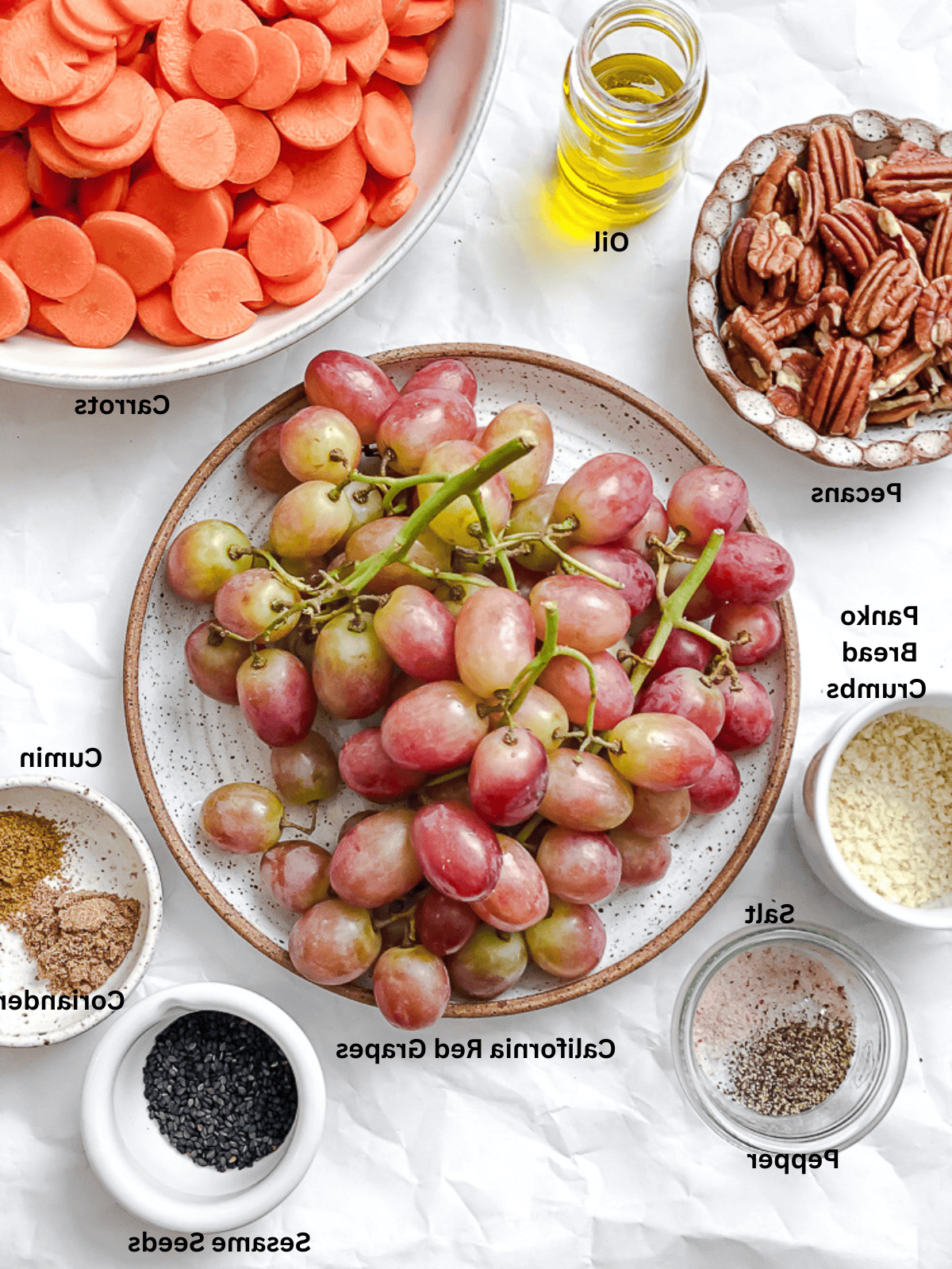 Karotten- und Kalifornische Trauben-Beilage 3 ingredients for Carrot Grape Side Dish measured out on a white surface