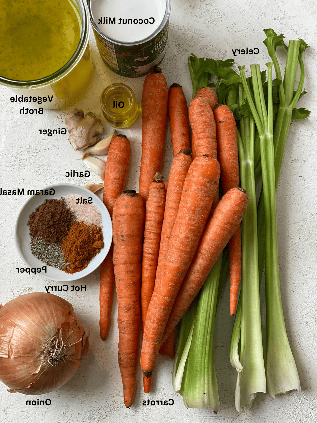 Cremige Curry-Karotten-Ingwer-Suppe 3 Zutaten für würzige Karotten-Suppe, auf einer weißen Oberfläche abgemessen.