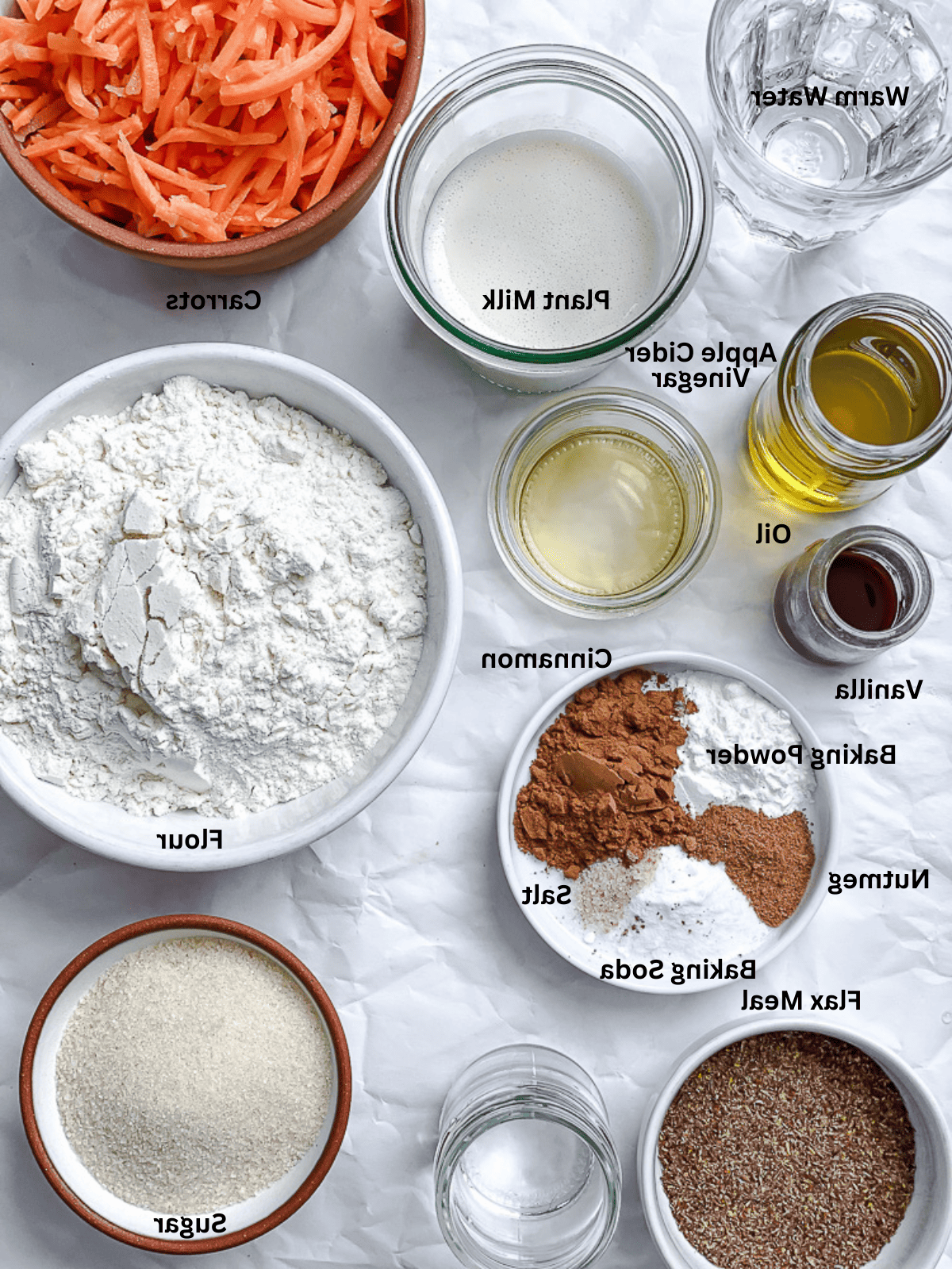 Veganer Karottenkuchen 3 Zutaten für veganen Karottenkuchen auf weißer Oberfläche