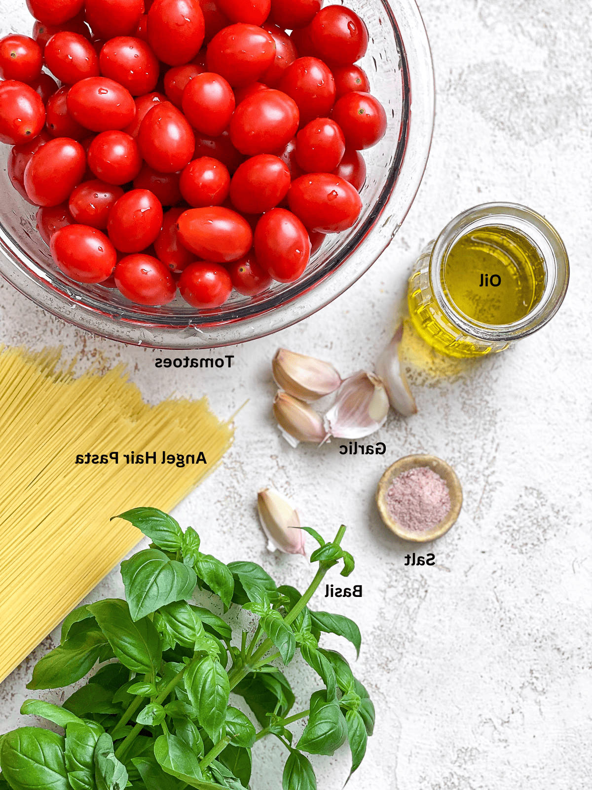 15-Minuten-Kirschtomaten-Basilikum-Pasta 3 Alle benötigten frischen Zutaten für die 15-Minuten-Kirschtomaten-Basilikum-Pasta auf einer weißen Oberfläche, bereit zur Zubereitung