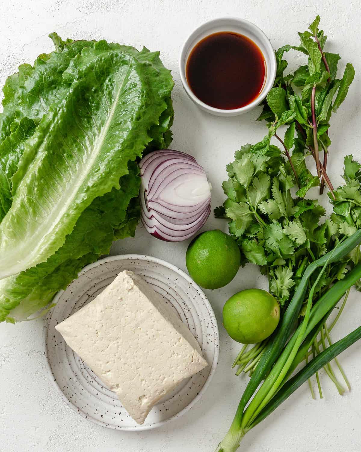 Veganer Tofu-Larb-Salat 3 Abgemessene Zutaten für Larb Salat auf weißer Oberfläche.