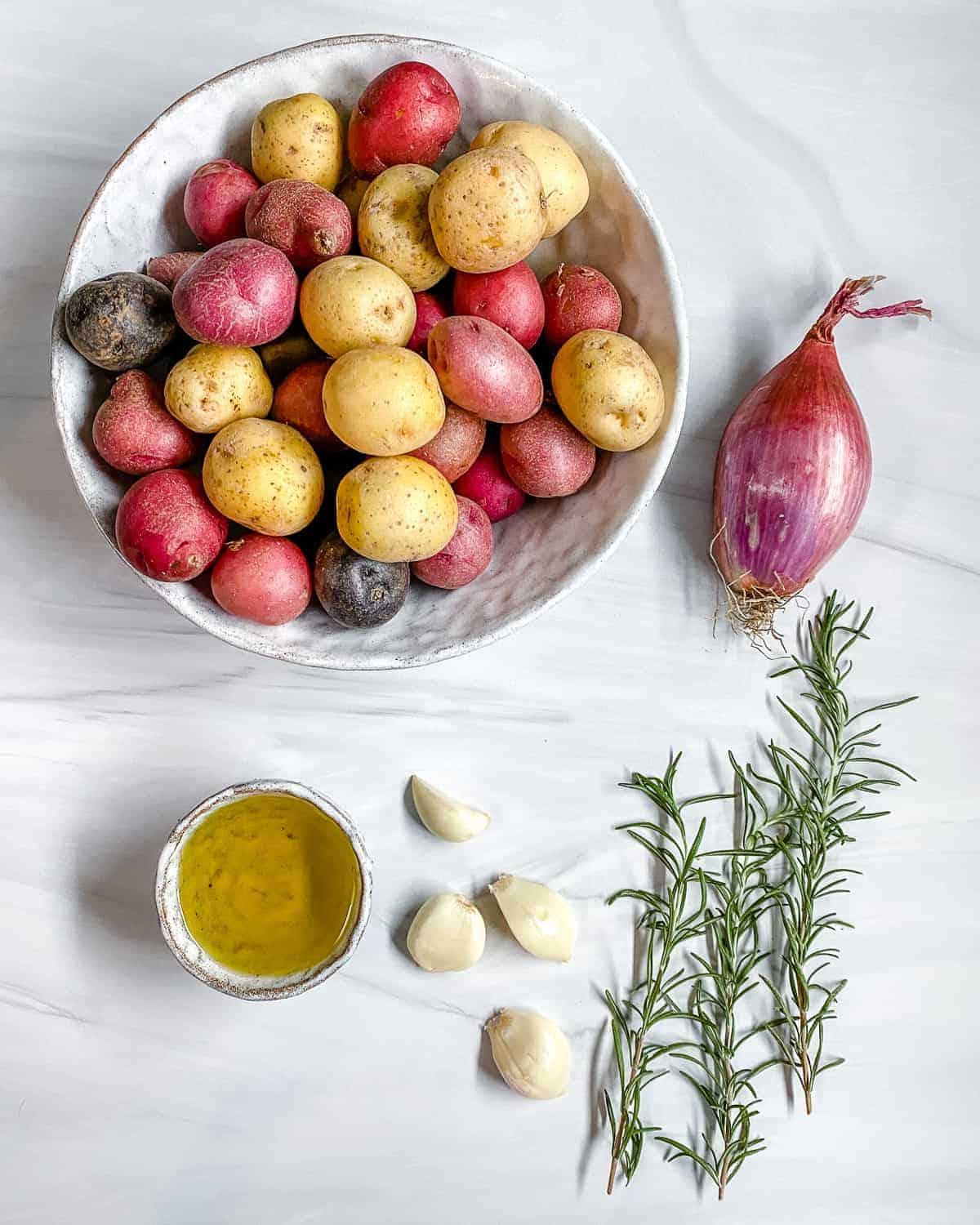ingredients for Roasted Rosemary Potatoes measured out against a white surface
