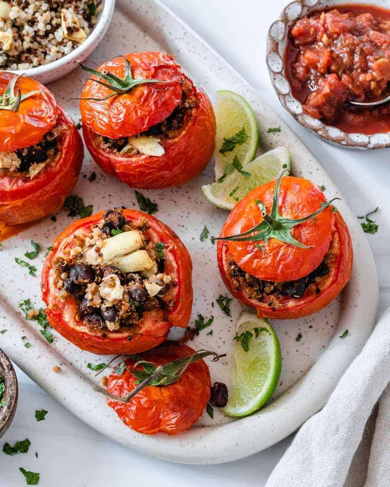 Gefüllte Tomaten 3 Fertige gefüllte Tomaten auf einem weißen Teller vor weißem Hintergrund
