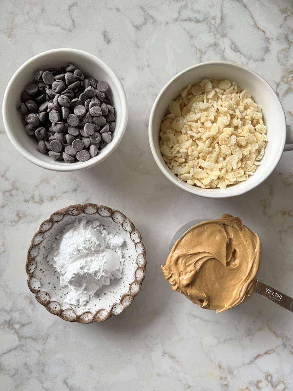 Vegane Schoko-Erdnussbutter-Kugeln ohne Backen mit Reis-Crispies 3 Zutaten für Erdnussbutter-Bonbons auf einer weißen Marmoroberfläche