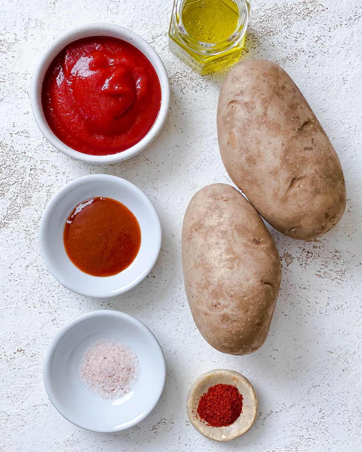 Zutaten für Patatas Bravas auf weißem Untergrund abgemessen