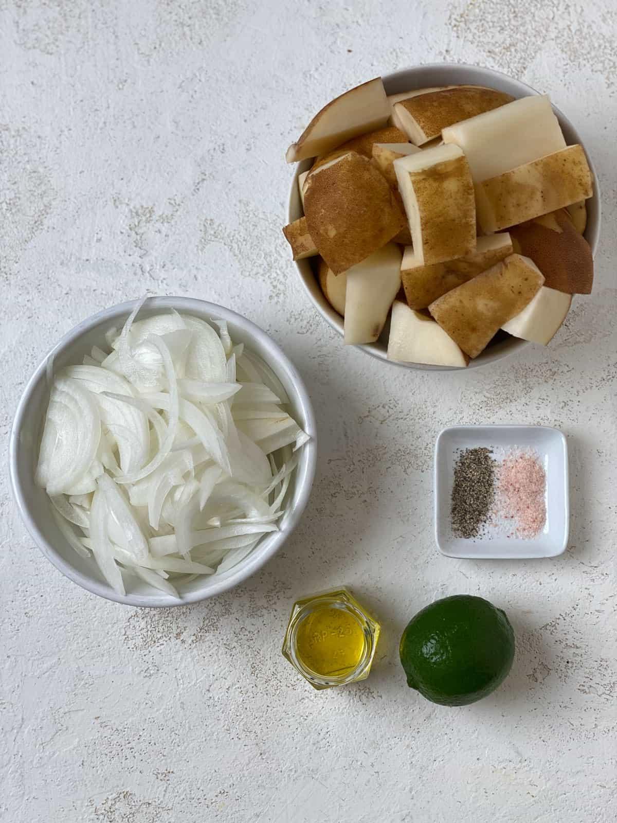 Knusprige Bratkartoffeln Rezept 3 Zutaten für knusprige Bratkartoffeln auf einer weißen Oberfläche abgemessen
