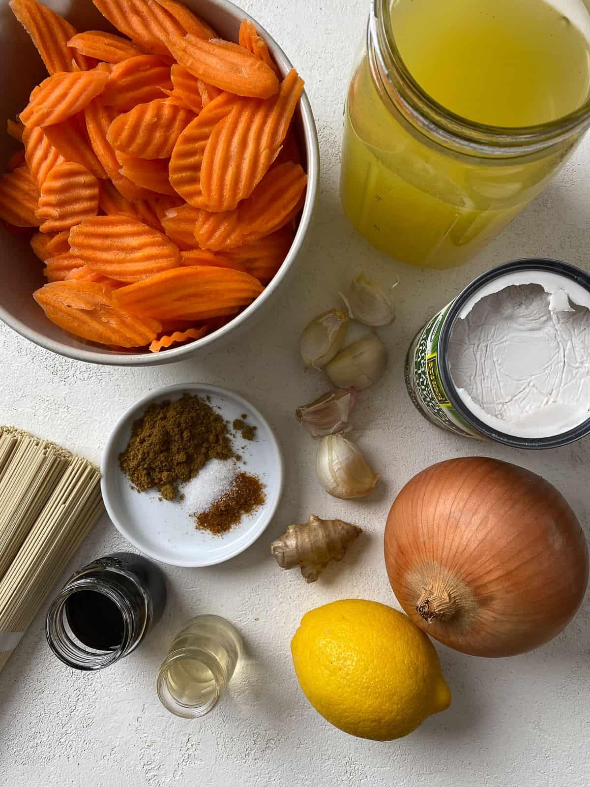 Karotten-Curry-Suppe mit Nudeln 3 Zutaten für Curry-Karotten-Suppe mit Nudeln, abgemessen auf weißem Untergrund