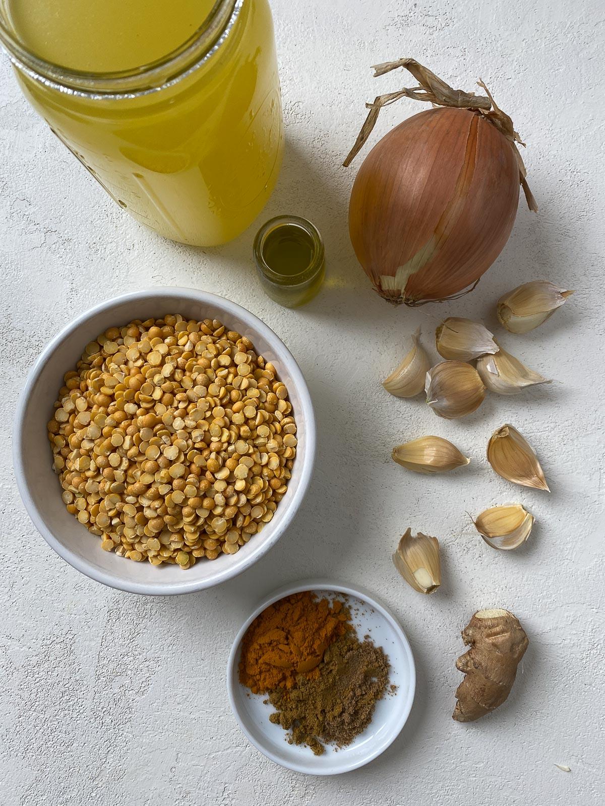 Einfaches gelbes Dal-Rezept 3 Zutaten für einfaches gelbes Dal auf weißer Oberfläche