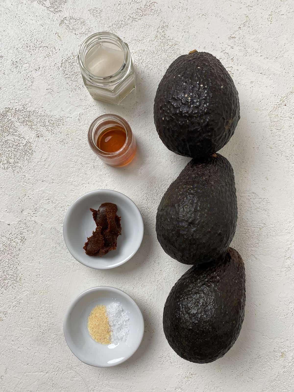Einfacher Avocado-Aufstrich 3 Zutaten für den einfachen Avocado-Aufstrich abgemessen auf weißem Hintergrund