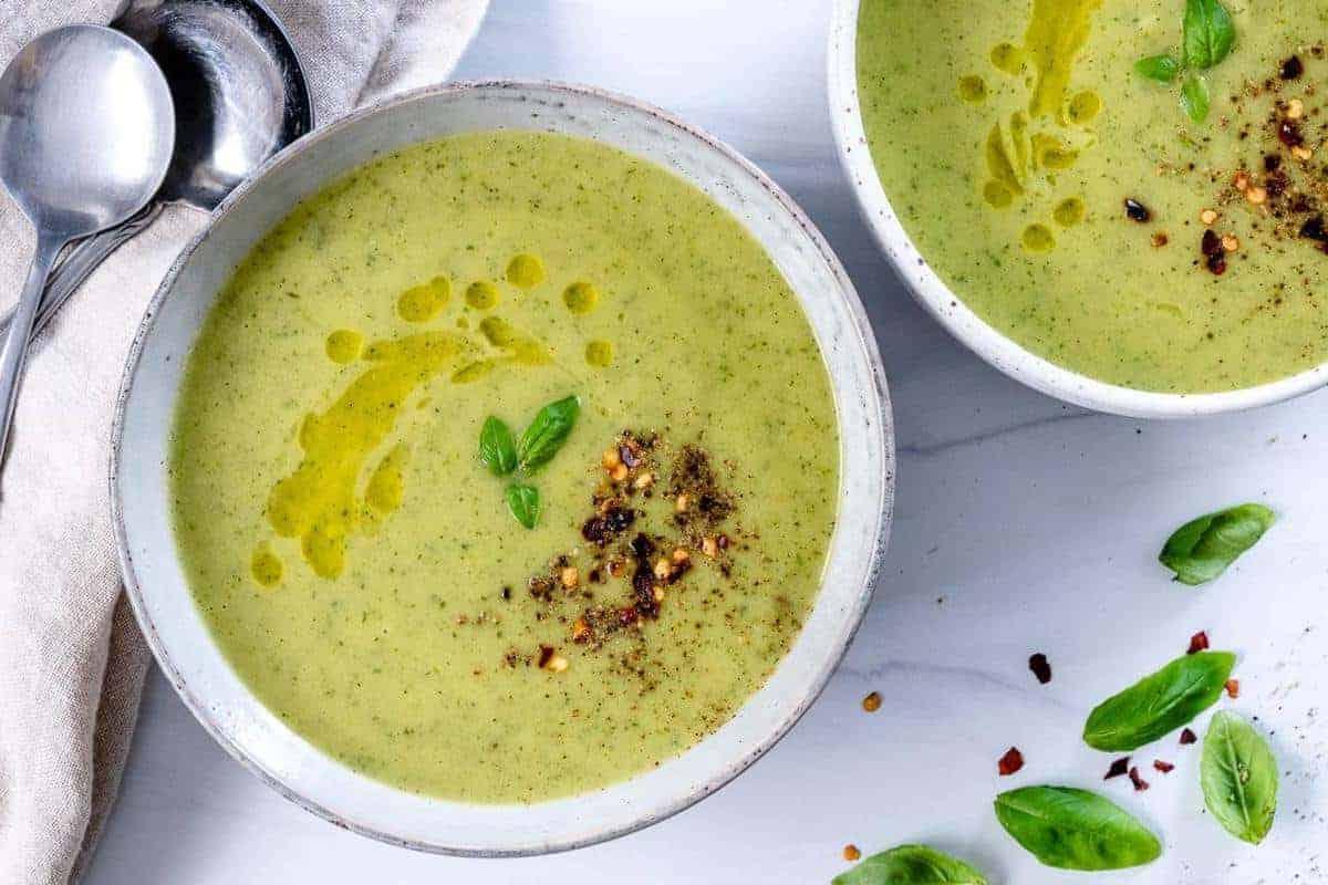 Fertige Zucchini-Suppe in einer weißen Schale vor weißem Hintergrund