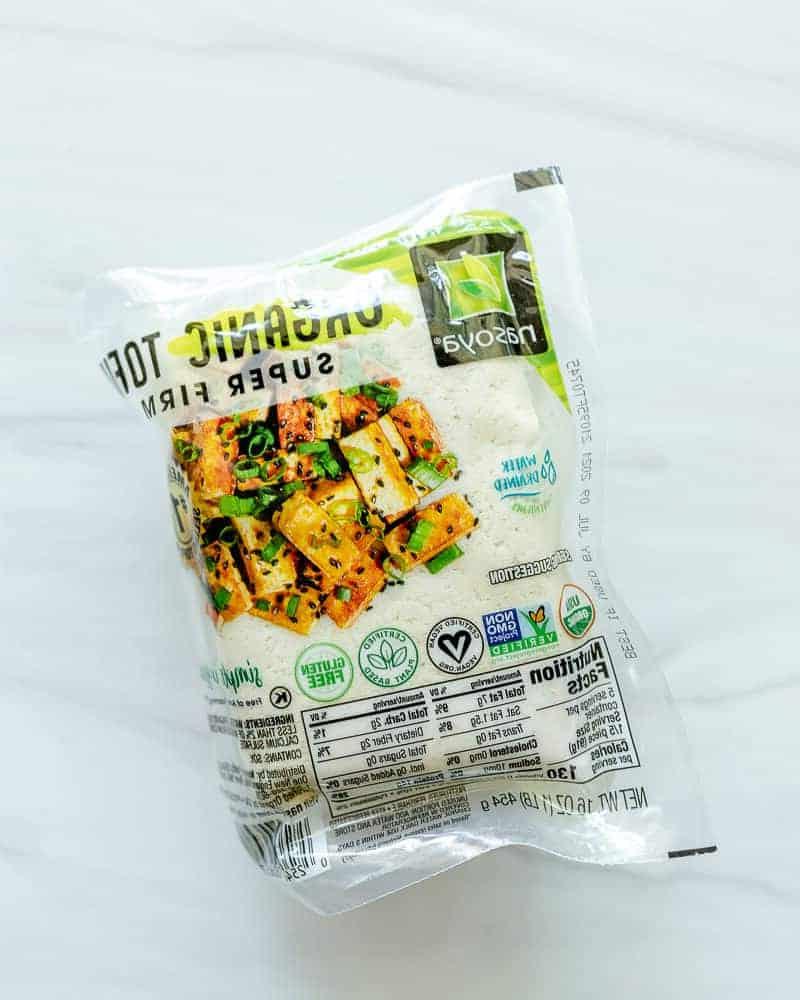 Vier verschiedene verpackte Tofu-Blöcke auf weißem Hintergrund, die die breite Verfügbarkeit von Tofu im Handel unterstreichen.