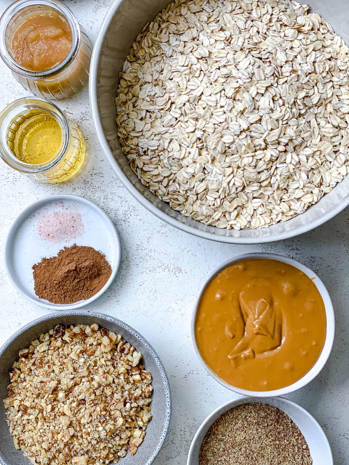 Einfaches Erdnussbutter Granola 3 ingredients for Easy Peanut Butter Granola measured out against a white surface