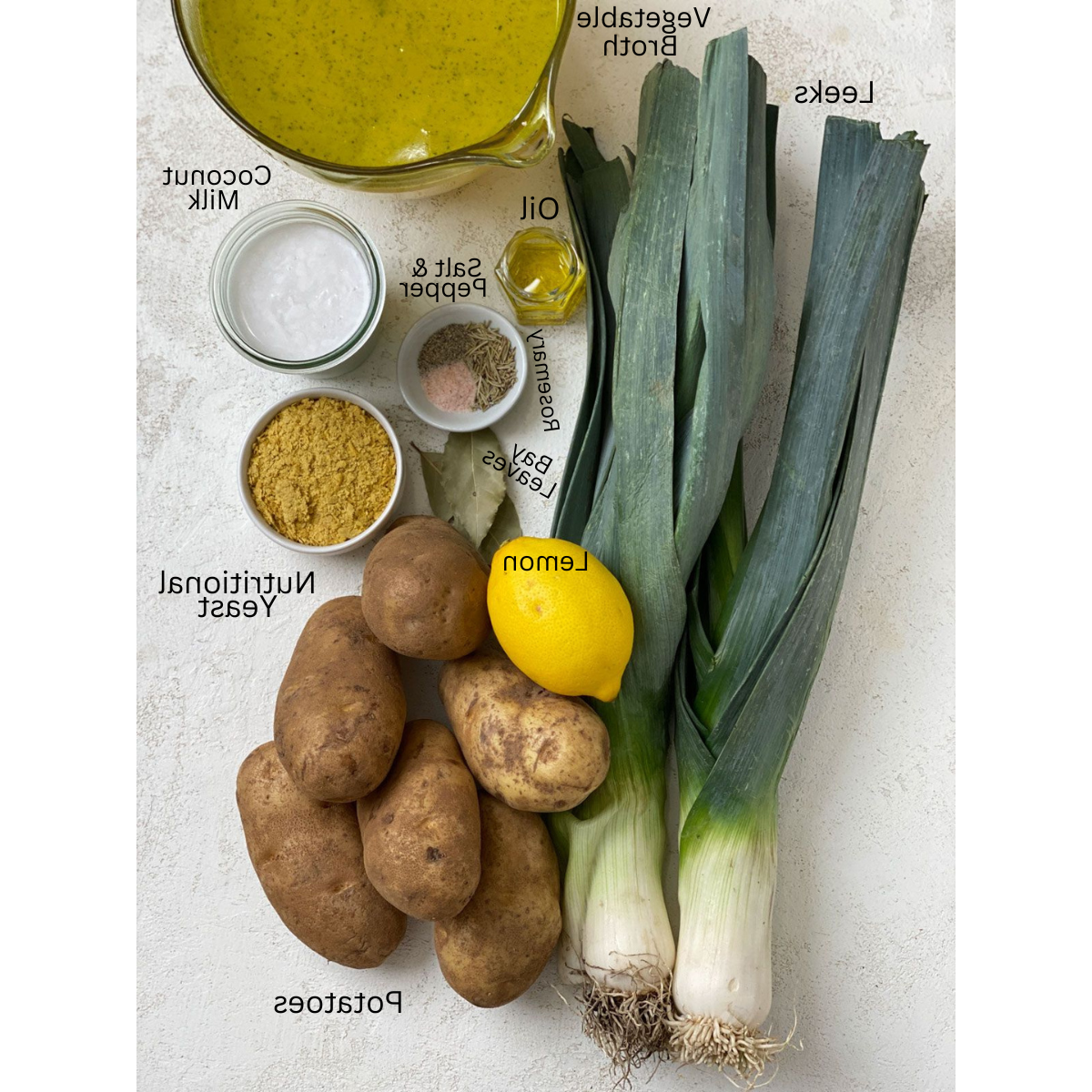Zutaten für cremige Kartoffel-Lauch-Suppe abgemessen auf weißer Oberfläche