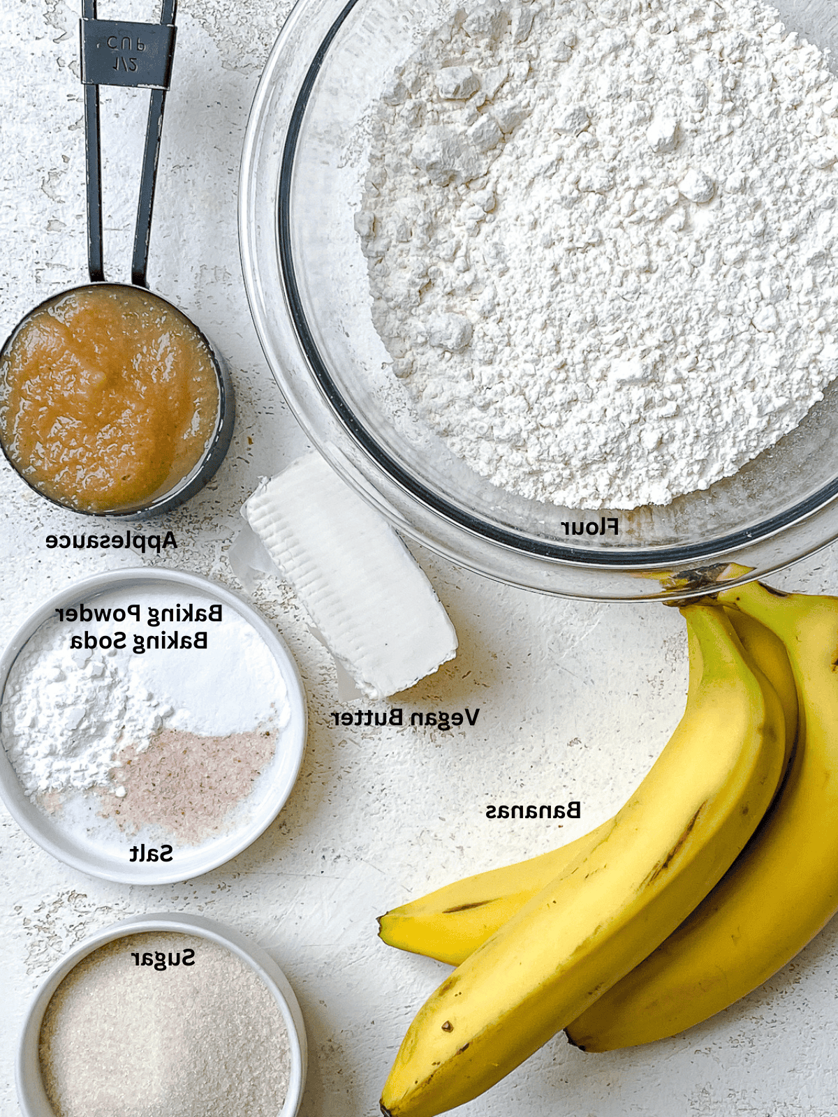 Einfaches Veganes Bananenbrot (Mit Apfelmus) 3 Zutaten für einfaches veganes Bananenbrot (mit Apfelmus), auf einer weißen Oberfläche abgemessen