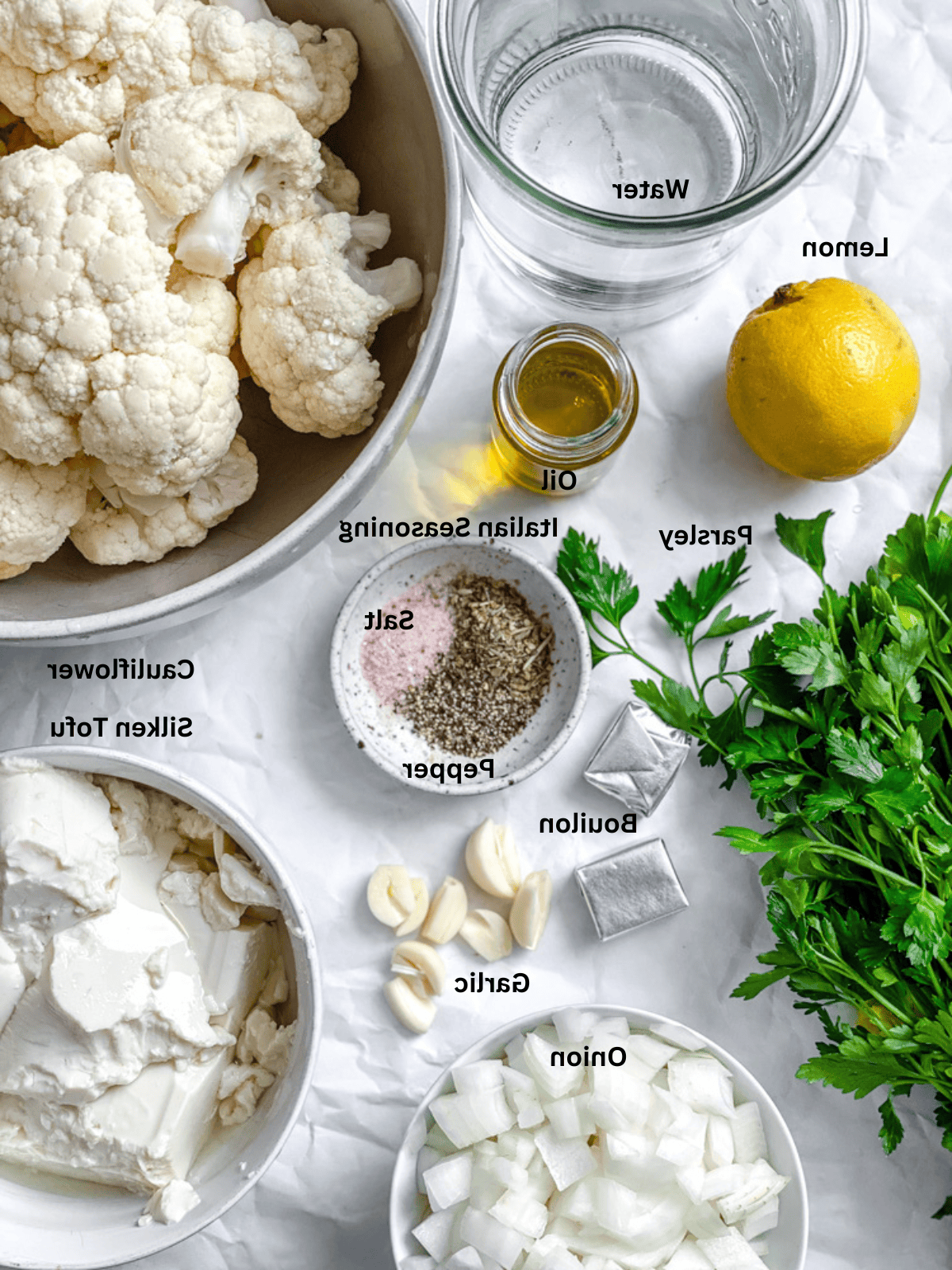 Geröstete Blumenkohlsuppe 3 Zutaten für Geröstete Blumenkohlsuppe auf einer weißen Oberfläche ausgebreitet.