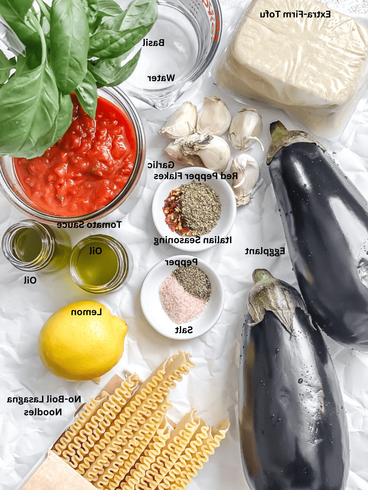 Vegane Auberginenlasagne 3 Zutaten für Vegane Auberginen-Lasagne auf einer weißen Oberfläche abgemessen