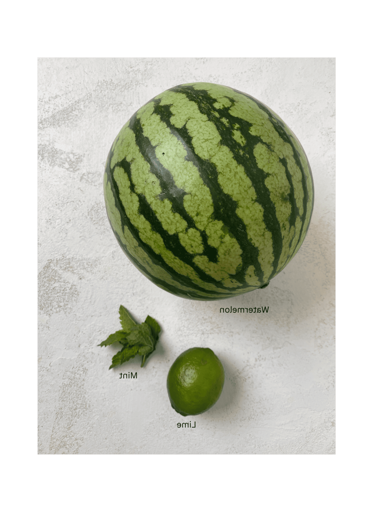 Gesundes Wassermelonen-Stieleis 3 Zutaten: Wassermelone, Limette und Minze auf einer weißen Oberfläche
