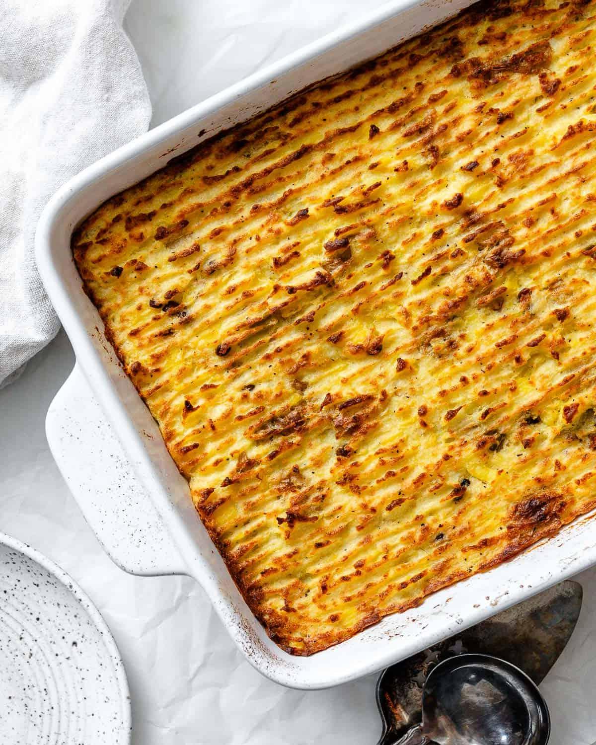 Veganer Linsen-Hirtenkuchen 21 Der fertig gebackene vegane Linsen-Hirtenkuchen in einer Auflaufform, goldbraun und appetitlich