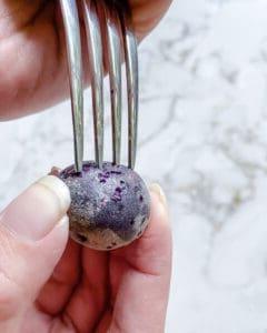 process of making small holes in raw small potatoes