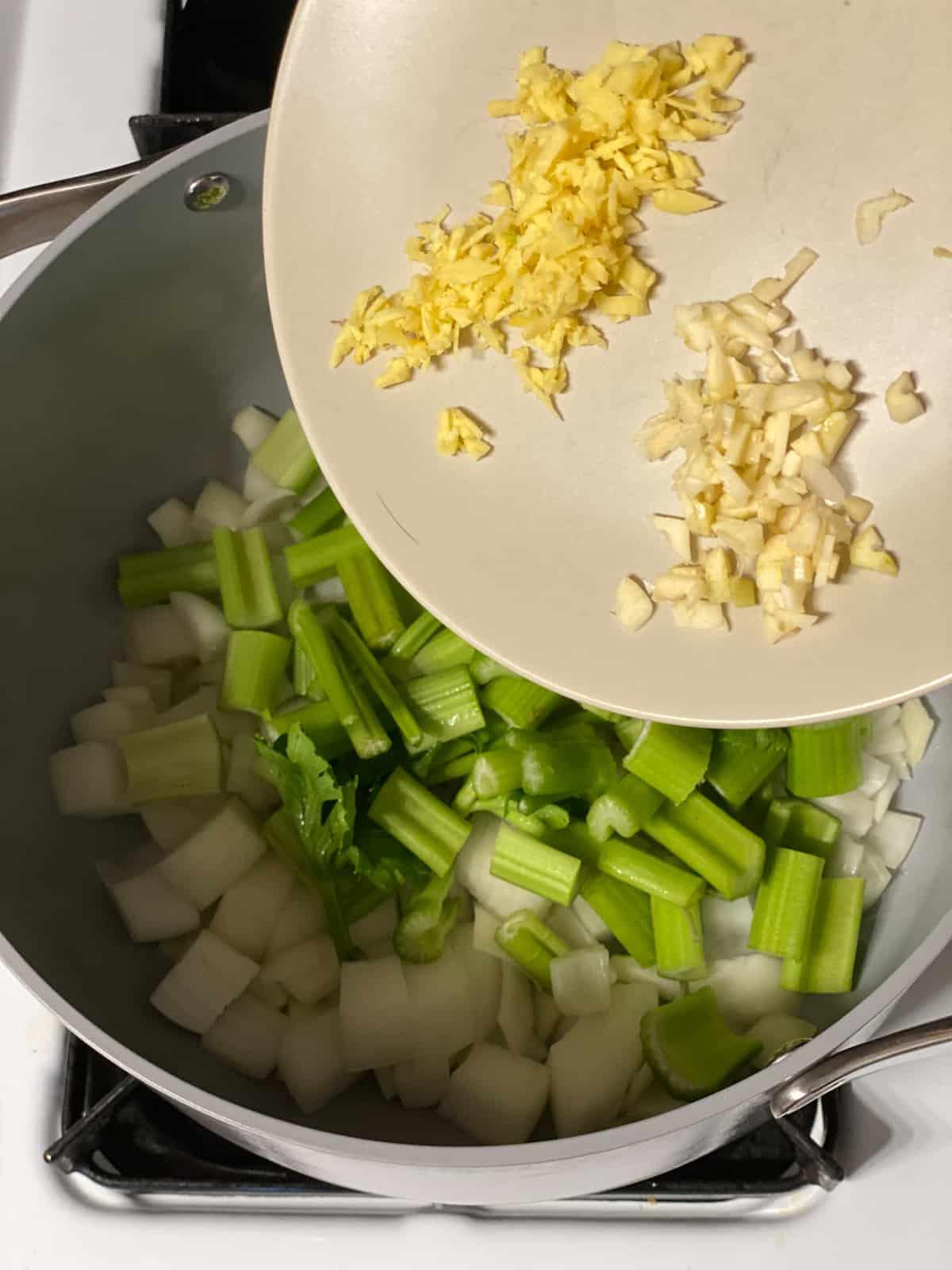 Cremige Curry-Karotten-Ingwer-Suppe 4 Prozessschritt: Gehackten Knoblauch in den Topf geben.