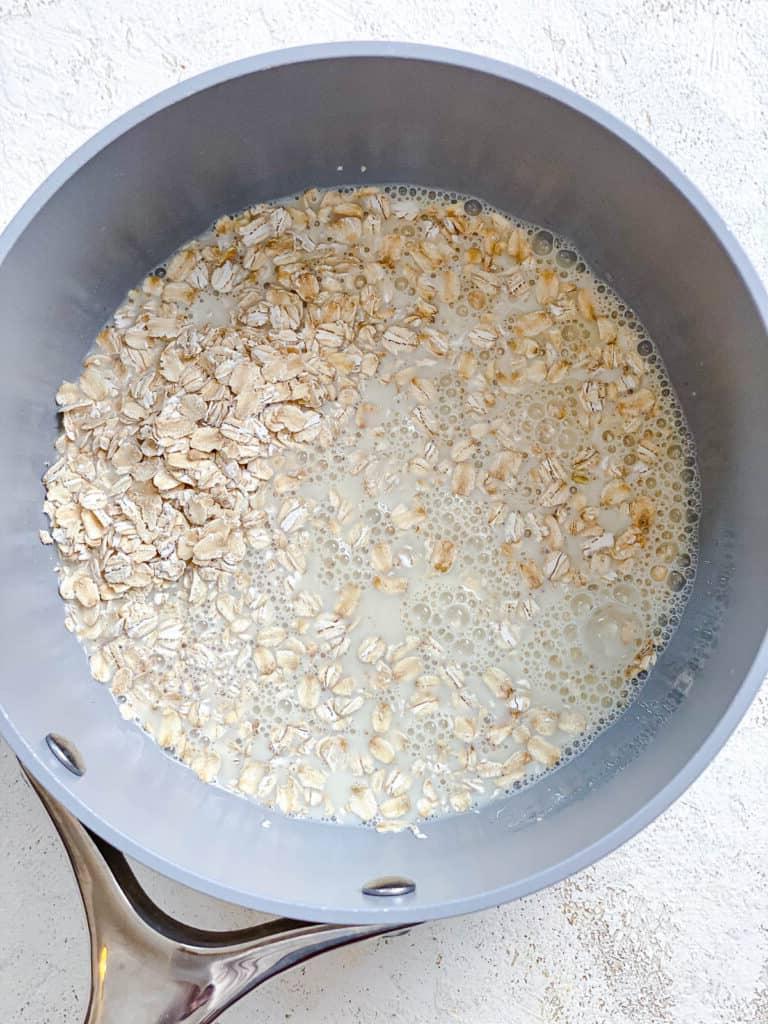 Einfacher Erdnussbutter-Porridge (+ Extras) 4 process shot of adding oats and plant-based milk in a pot