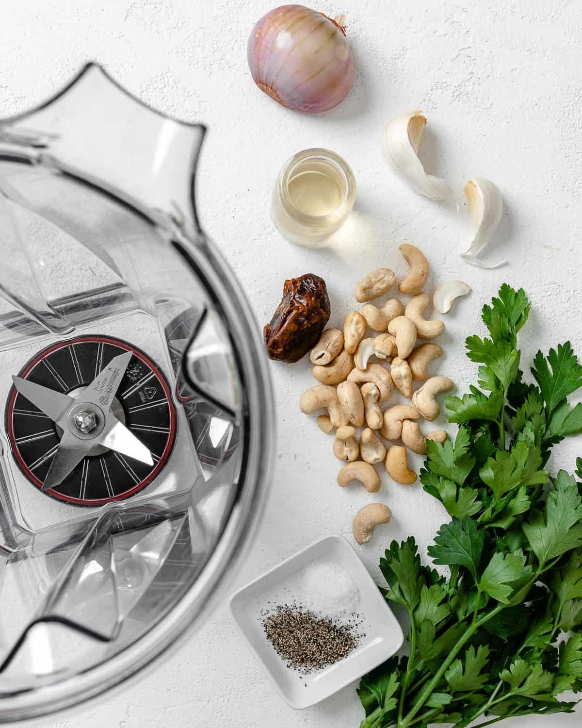 Cremige Vegane Knoblauchsoße 4 Zutaten für cremige vegane Knoblauchsauce neben Mixer vor weißem Hintergrund
