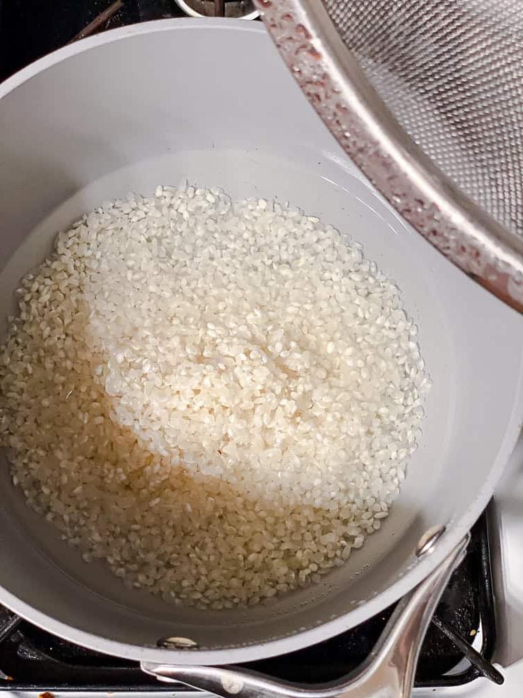 Sushi-Schüssel 4 Reis kochen in einem grauen Topf.