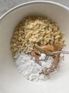 Vegane Schoko-Erdnussbutter-Kugeln ohne Backen mit Reis-Crispies 4 Prozess des Mischens der Zutaten für Erdnussbutter-Bonbons in einer Schüssel