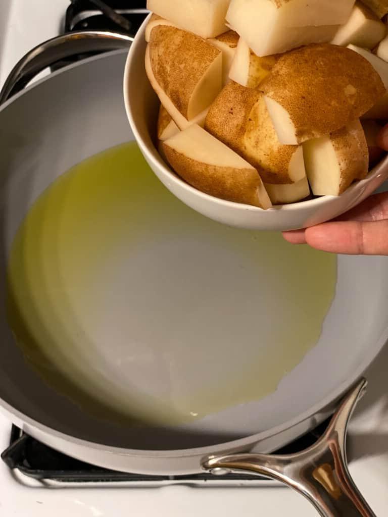 Knusprige Bratkartoffeln Rezept 4 Arbeitsschritt: Kartoffeln in die Pfanne geben