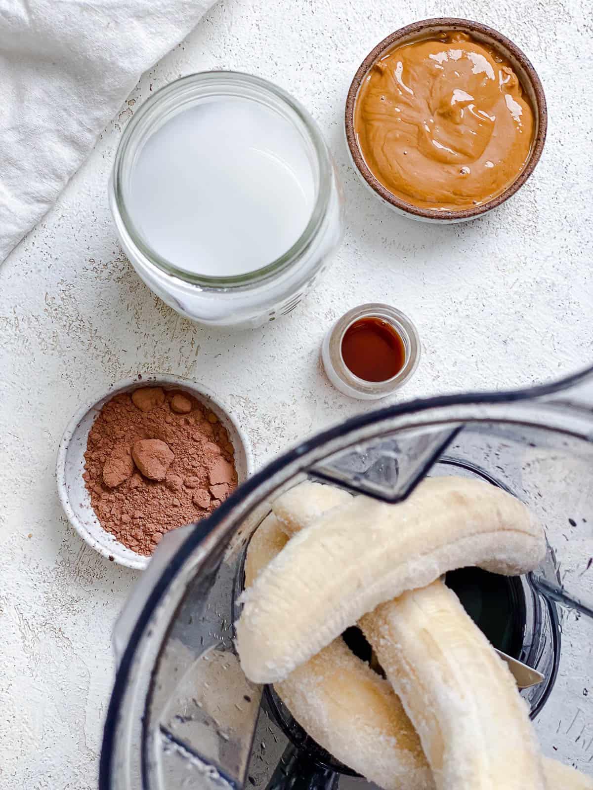Schokoladen-Bananen-Milchshake 4 Prozessaufnahme, die zeigt, wie Zutaten in den Mixer gegeben werden