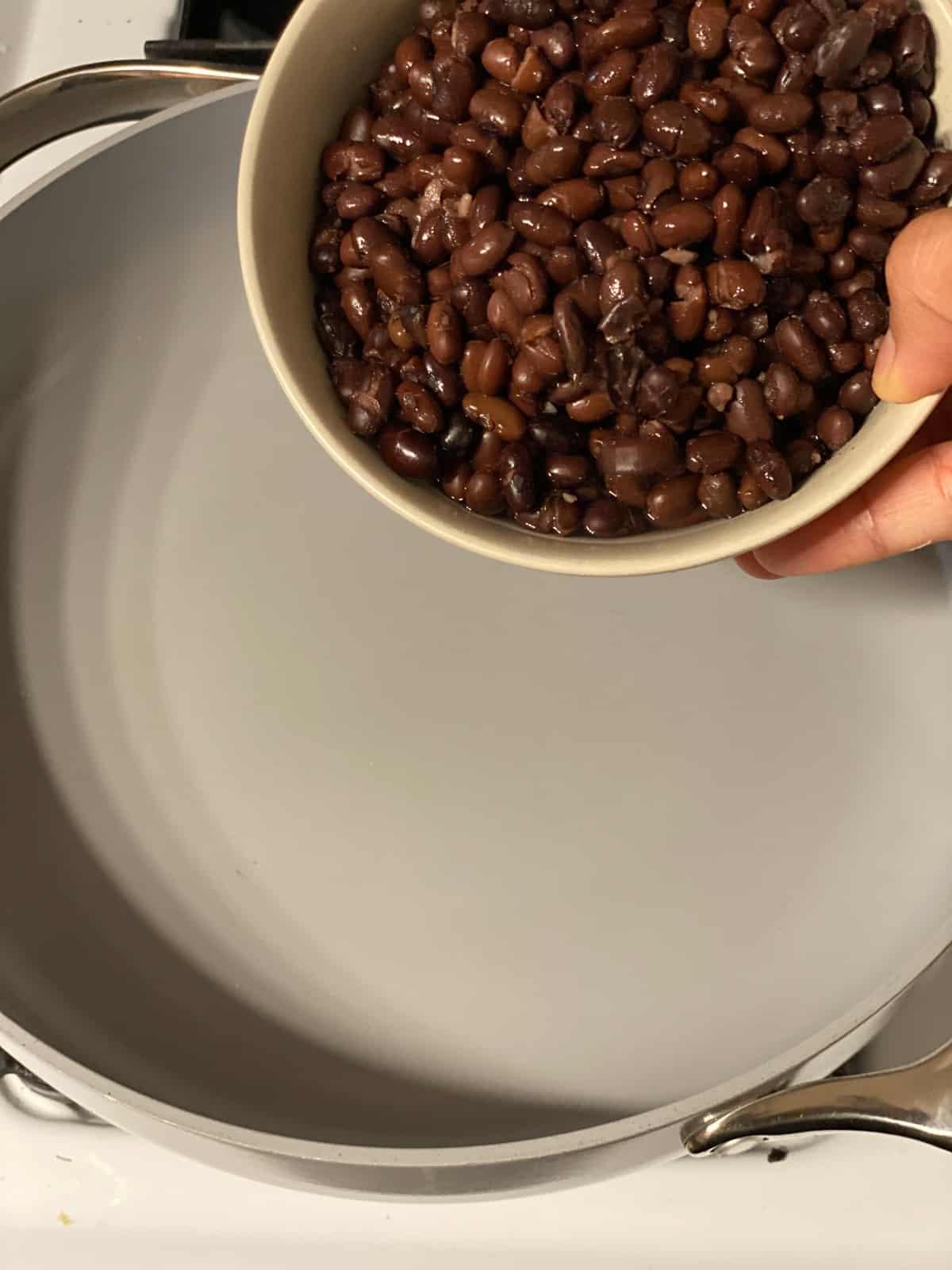Vegane Schwarze-Bohnen-Salatwickel 4 process shot of adding beans to a pan