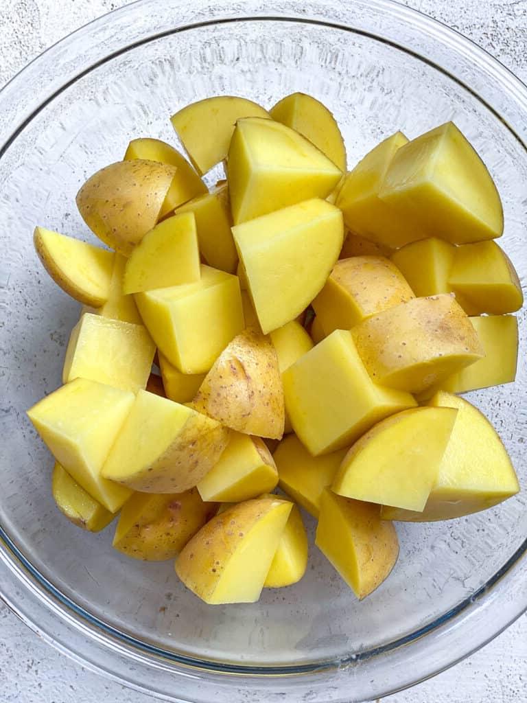 Veganer Linsen-Hirtenkuchen 4 Geschnittene Kartoffeln in einer Schüssel bereit zum Kochen