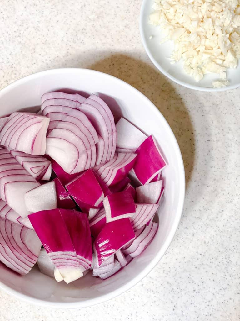Einfache Penne alla Norma (Auberginenpasta) 4 sliced onions and garlic in a bowl