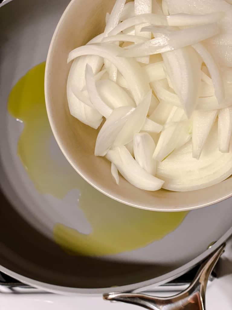 Cremige Reisnudelpfanne 4 Zwiebeln werden in die Pfanne gegeben