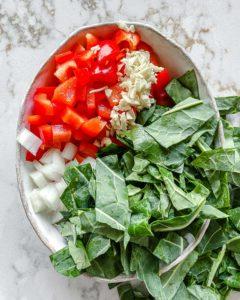 Scharfer Blattkohl 4 chopped ingredients for Spicy Collard Greens measured out against a white surface in a white bowl