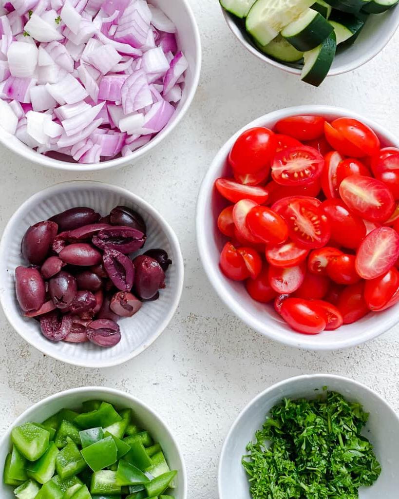 **Mediterraner veganer Nudelsalat** 4 Zutaten für mediterranen veganen Nudelsalat auf weißem Untergrund abgemessen