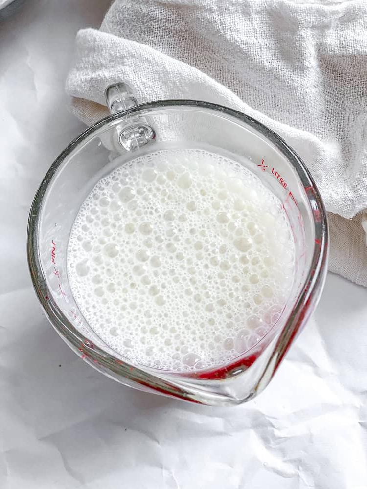 Butternusskürbis-Kuchen 4 Prozessaufnahme, die die Mischung aus Pflanzenmilch und Apfelessig in einer Tasse zeigt