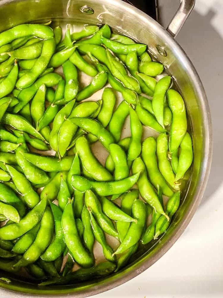 process shot showing edamame cooking in a pan