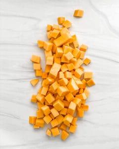 Roher gewürfelter Butternut-Kürbis auf einer weißen Marmoroberfläche