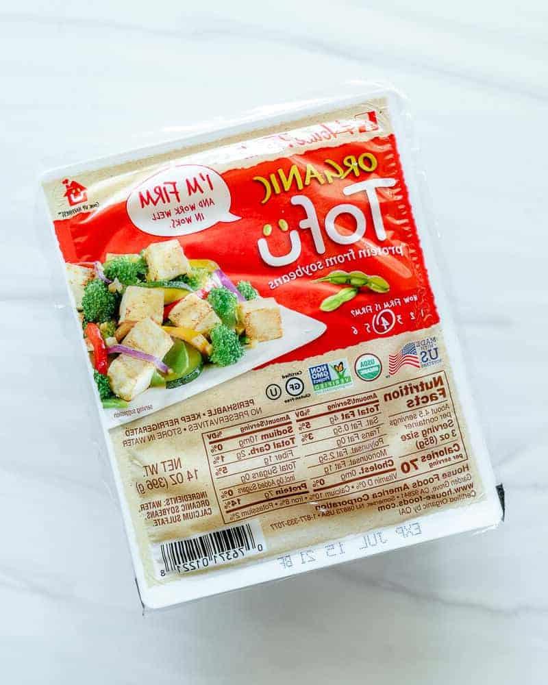Vier verschiedene verpackte Tofu-Blöcke auf weißem Hintergrund, die die unterschiedlichen Härten von Tofu demonstrieren.