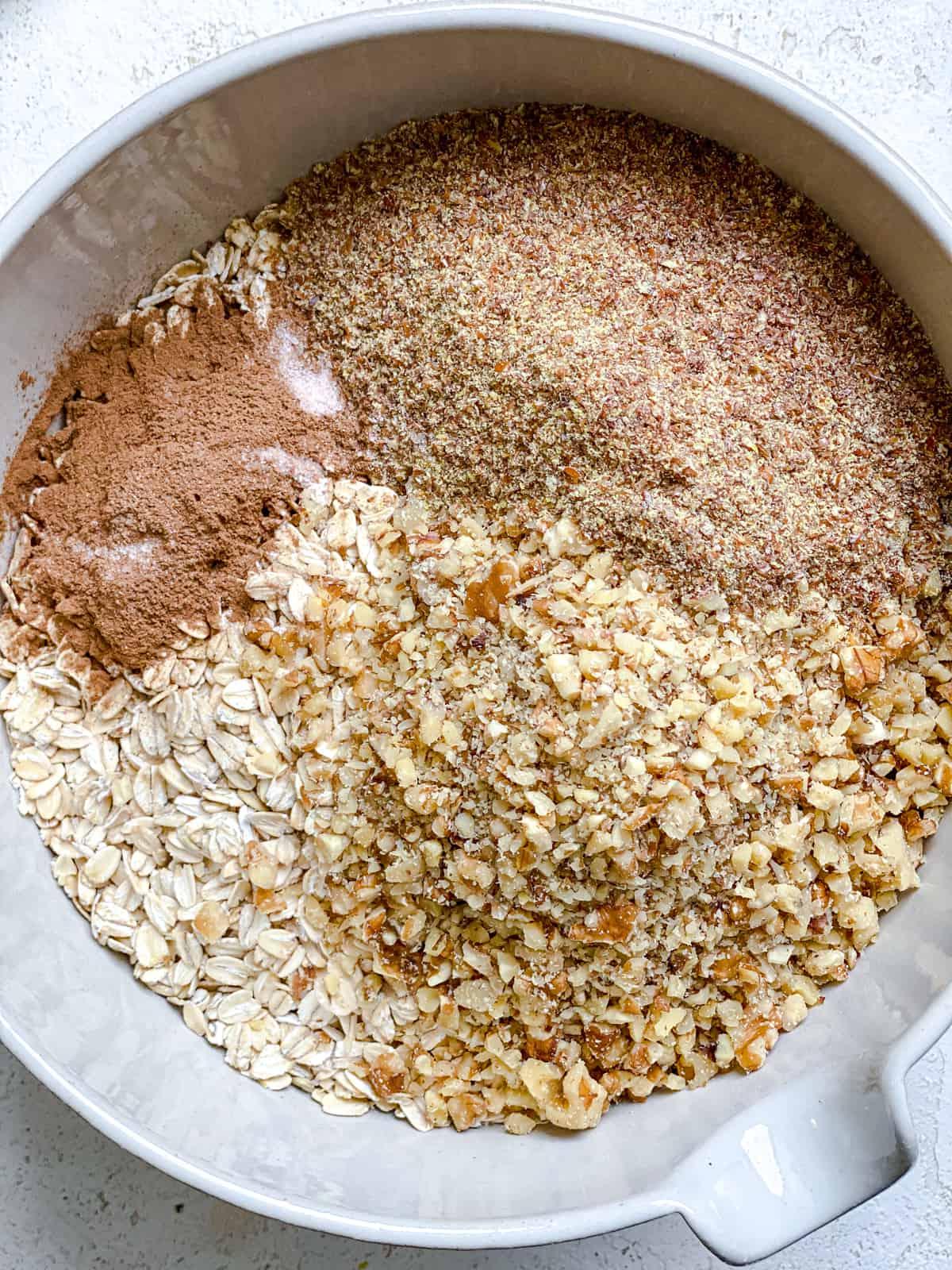 Einfaches Erdnussbutter Granola 4 process shot of ingredients mixed together in a bowl