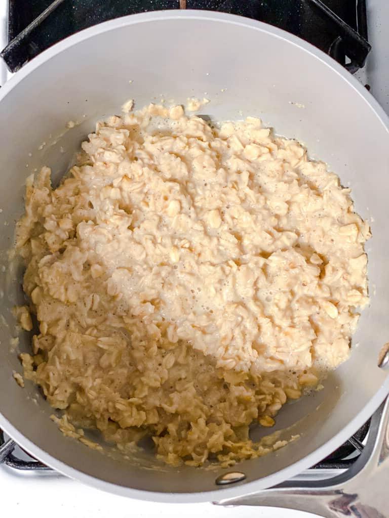 Einfacher Erdnussbutter-Porridge (+ Extras) 5 process shot mixing oats and plant-based milk in a pot