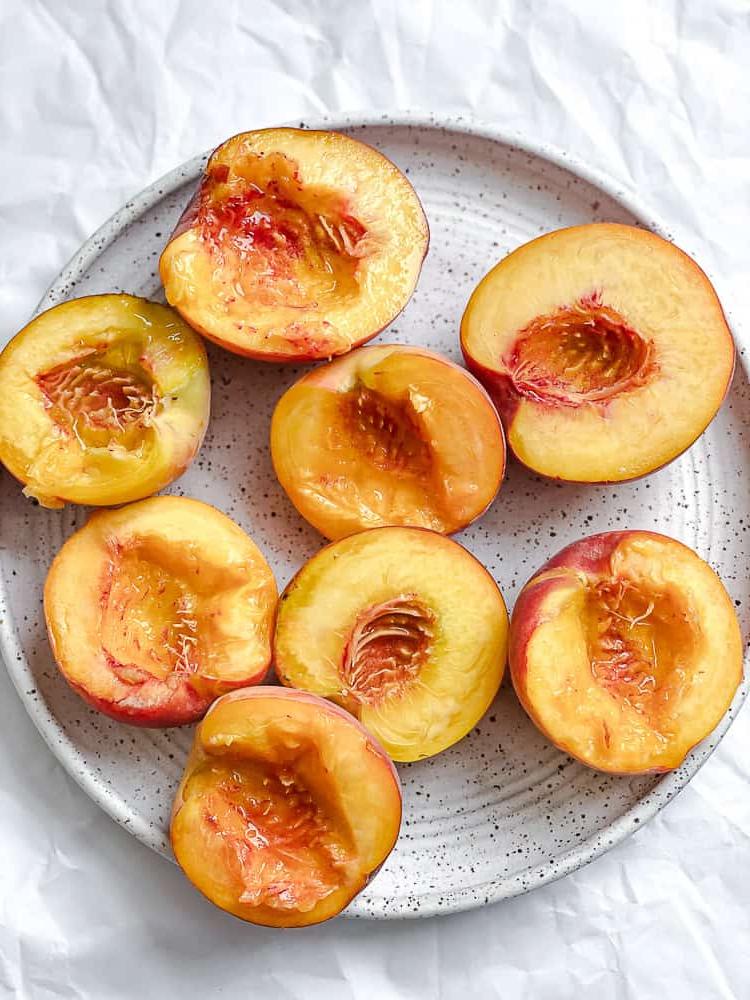 Peach Melba 5 Halbierte und entsteinte Pfirsiche liegen auf einem Teller.