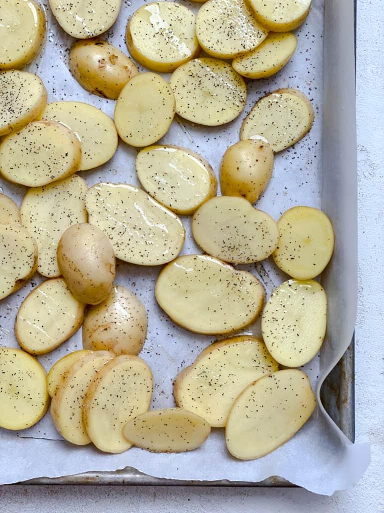 Gesunder Gerösteter Kartoffelsalat 5 Geschnittene Kartoffeln auf einem Backblech, gleichmäßig verteilt für optimales Rösten