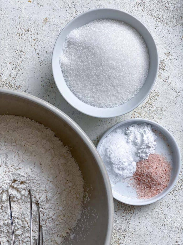 Zutaten für veganen Geburtstagskuchen [Funfetti Kuchen] auf einer weißen Oberfläche