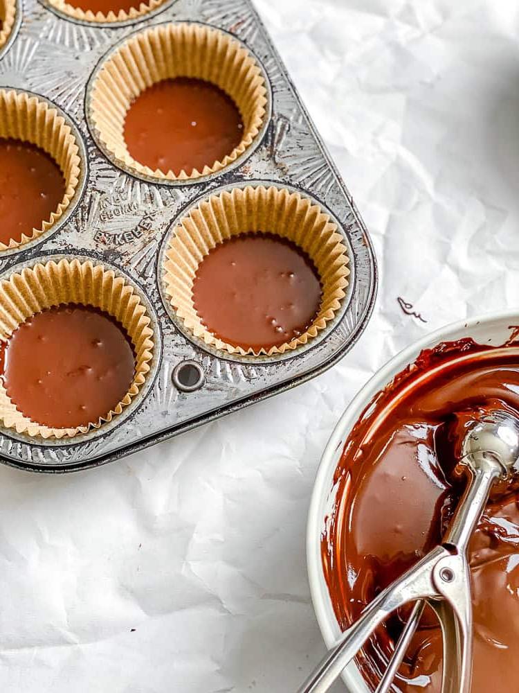 Prozessaufnahme: Vegane Schokolade in ein Muffinblech geben.