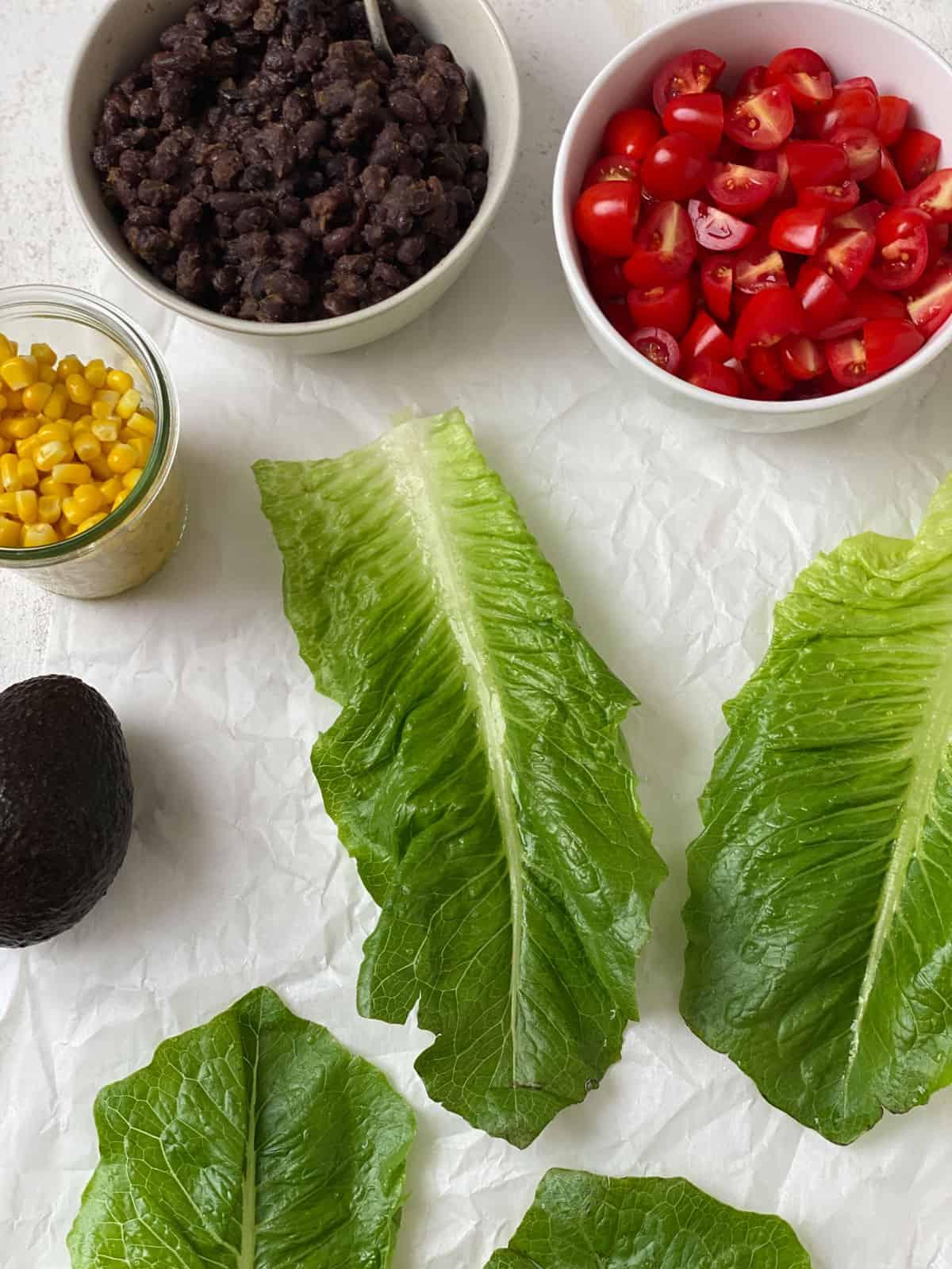 Vegane Schwarze-Bohnen-Salatwickel 5 ingredients for Vegan Black Bean Lettuce Wraps measured out against a white surface