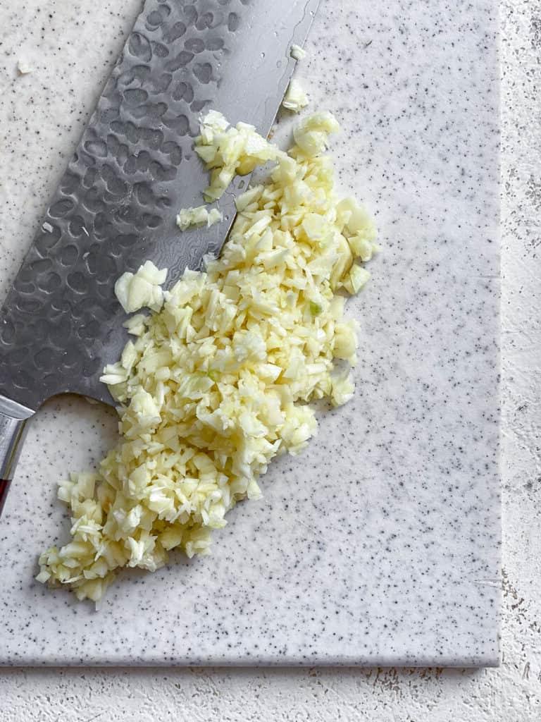 Einfaches Tofu Adobo 5 process shot of slicing garlic on cutting board