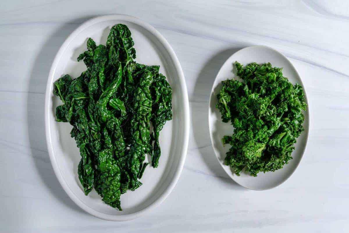 Dino Kale and Curly Kale on White Serving Dishes on a a Marble Surface 