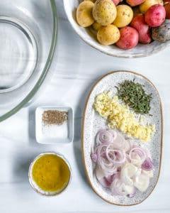 ingredients for Roasted Rosemary Potatoes measured out against a white white surface